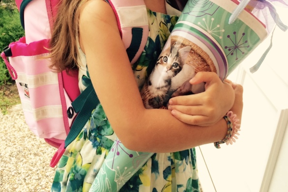 Mädchen mit Zahnlücke am ersten Schultag umarmt ihre Schultüte